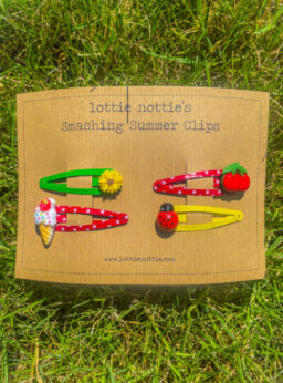 A card of lottie nottie hair clips, sunflowers on green, cherries on red spotty clips, ice-creams on red spotty clips and ladybirds on yellow.